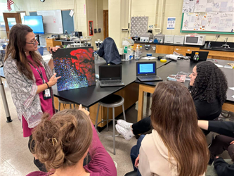 a teacher showing a tour group a display 