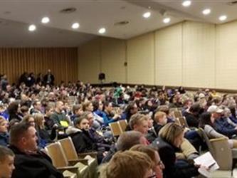 visitors in the auditorium listen to a tour guide