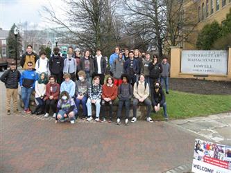 Students outside of a college building posing in a group photo
