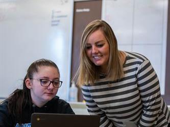 A teacher assisting a student with work