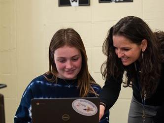 A teacher assisting a student with work