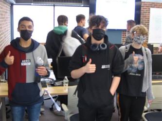 Students giving the camera a thumbs up as they walk by