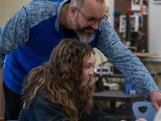 A teacher assisting a student with work