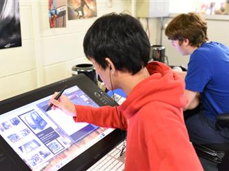 A student drawing on a large tablet